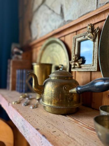 an old tea kettle sitting on a wooden table at Forest Lodge & Spa in Gauja National Park - Kaķukalns in Straupe
