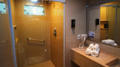 a bathroom with a shower with a glass door at Pratagy Beach All Inclusive Resort in Maceió