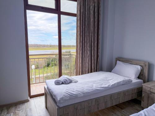 a bedroom with a bed and a large window at Three Lion Hotel in Batumi