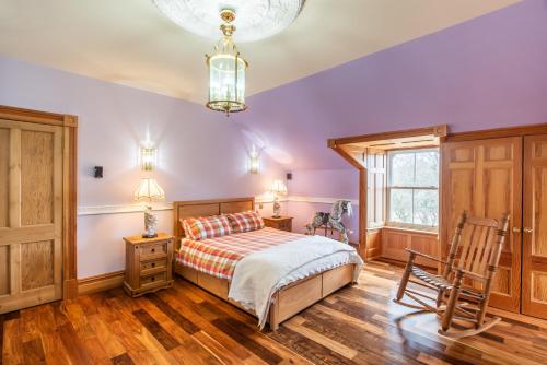 a bedroom with a bed and a wooden floor at The Doune, Luxury Traditional Country House with hot tub in Inverness