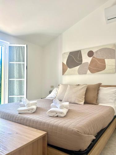 a bedroom with a large bed with towels on it at Ardesia apartment in Crocetta