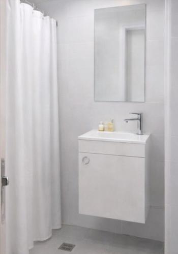 a bathroom with a sink and a white shower curtain at R suite in Netanya