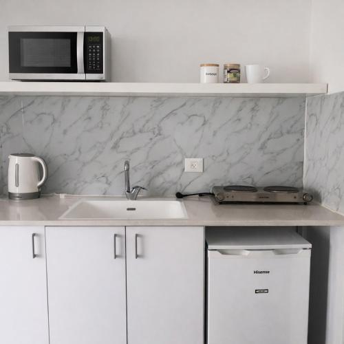 a kitchen with a sink and a microwave at R suite in Netanya