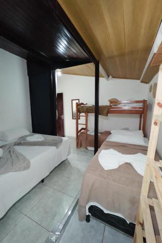 a bedroom with two beds and a piano at Casa da Silvana in Fernando de Noronha