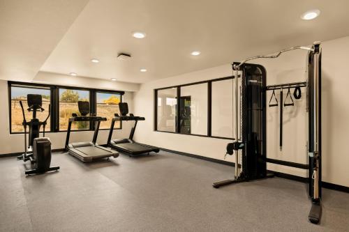a gym with cardio equipment in a room with windows at LivAway Suites Phoenix-Glendale in Glendale
