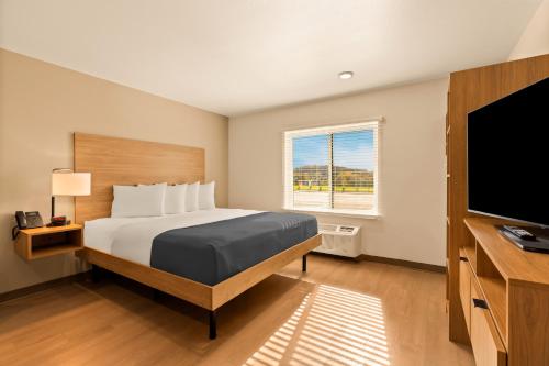 a bedroom with a bed and a flat screen tv at LivAway Suites Phoenix-Glendale in Glendale