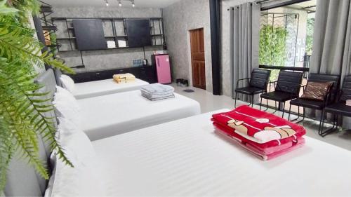 a room with a bed with chairs and a table at Hideout Homestay in Ban Rai Pa Yoe