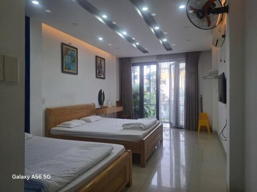 a bedroom with two beds and a window at Khoi Nguon in Danang