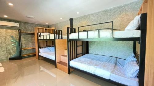 a room with three bunk beds in it at Hideout Homestay in Ban Rai Pa Yoe