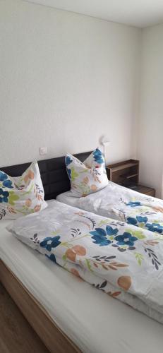 a bed with a colorful comforter and pillows on it at Gasthof Moosmatt in Egolzwil