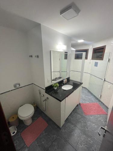 a bathroom with a toilet and a sink and a mirror at Casa Vibra Luz Guest House Familiar in Campeche