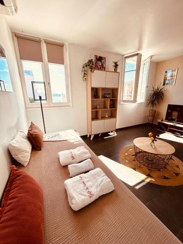 a living room with a large bed and a table at La Madrague, Studio vue mer, Centre historique in Sainte-Maxime