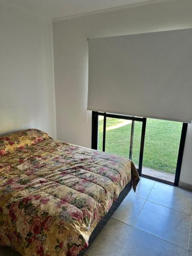 a bedroom with a bed and a large window at Departamento y aire libre in General Pico
