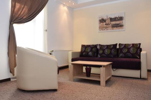a living room with a couch and a table at Guest House Vila Lujza in Palić