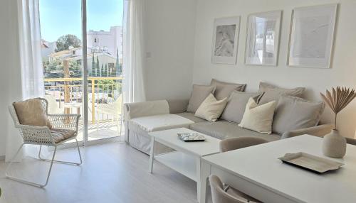 a white living room with a couch and a table at White Aura by Staycom in Paphos