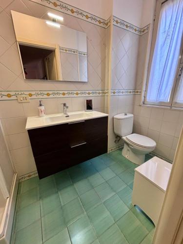 a bathroom with a sink and a toilet and a mirror at Duomo Square Apartment in Taormina