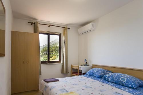 a bedroom with a bed and a window at Robinson Danica 1 in Gornji Dingač