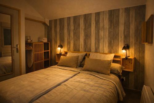 a bedroom with a large bed with two lamps at Cottage cosy avec spa privatif - escapade romantique Val de Loire in Chouzy-sur-Cisse