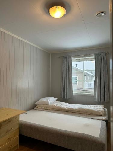 a small bedroom with a bed and a window at Trysil Central Villa in Trysil