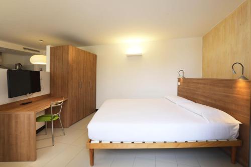 a bedroom with a bed and a desk and a tv at Lago & Monte Varese Apartments near Hospital and University in Varese