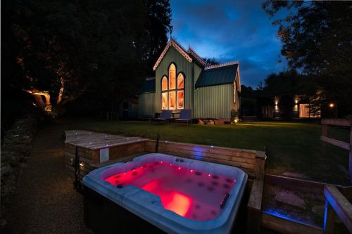 ein Whirlpool vor einer Kirche bei Nacht in der Unterkunft The Tabernacle, Design-led Converted Chapel with Hot Tub, Highland Perthshire in Aberfeldy