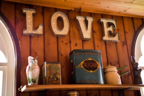 Eine Holzwand mit einem Schild, auf dem „Liebe“ steht. in der Unterkunft The Tabernacle, Design-led Converted Chapel with Hot Tub, Highland Perthshire in Aberfeldy