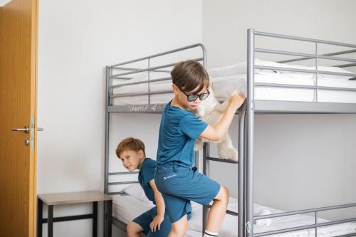 a young boy holding a teddy bear in a bunk bed at Hotel Můstek in Liberec