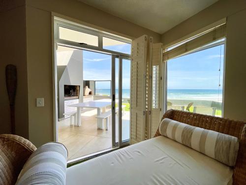 a living room with a couch and a view of the ocean at Pebble Beach Seafront Condo in Swakopmund