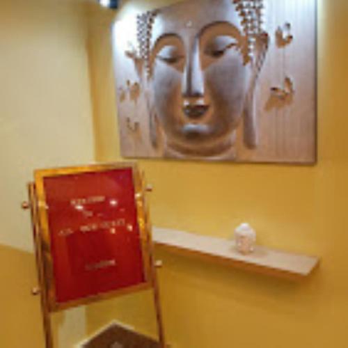 ein Gemälde eines Gesichts an der Wand eines Badezimmers in der Unterkunft Hotel Hempi in Diphu