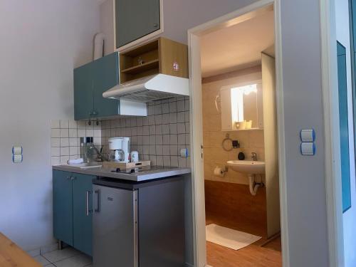 a small kitchen with blue cabinets and a sink at Rethymno Blue Residence in Rethymno