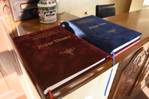 two books sitting on top of a wooden table at Guest House Vila Lujza in Palić