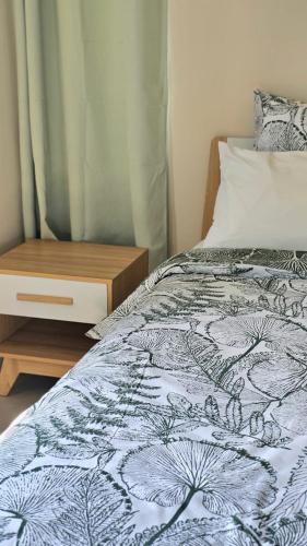 a bed with a blue and white blanket and a night stand at Entire villa with private pool and seaview Albion Mauritius in Albion