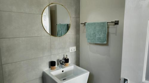 a bathroom with a white sink and a mirror at Entire villa with private pool and seaview Albion Mauritius in Albion