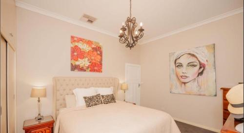 a bedroom with a bed and a painting on the wall at Cozy Cottage with Full Kitchen, Backyard & Patio in Tamworth