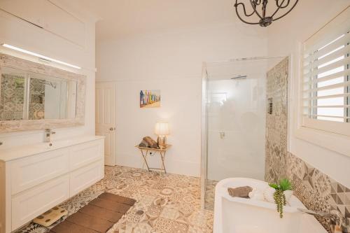 a bathroom with a shower and a white tub at Cozy Cottage with Full Kitchen, Backyard & Patio in Tamworth