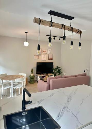 a kitchen with a sink and a living room at ABA Malaguita in Conil de la Frontera