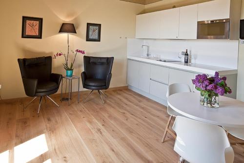 a kitchen with a table and two chairs and a table with purple flowers at Spa Resort Fonte Alla Lepre in Riparbella