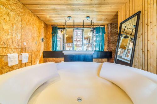 a white bath tub in a bathroom with a mirror at LOFT d'exception Hypercentre avec Piscine in Brive-la-Gaillarde