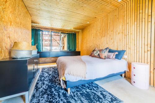a bedroom with a bed and a wooden wall at LOFT d'exception Hypercentre avec Piscine in Brive-la-Gaillarde