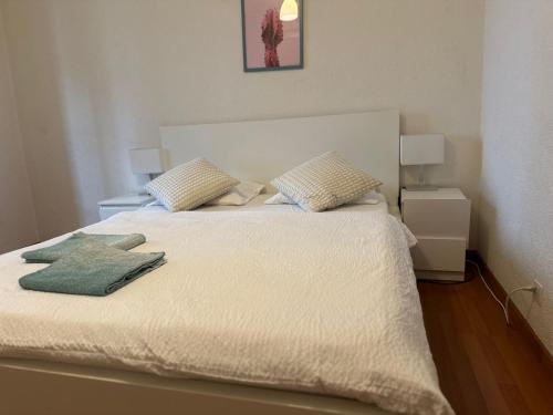 a bedroom with a white bed with two night stands at Zimmer In Luzern in Arni Alp