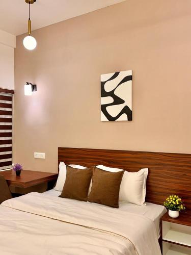 a bedroom with a large bed with brown and white pillows at Global Residency in Kanjirapalli