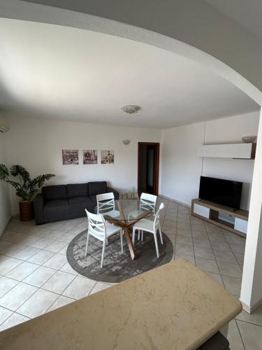 a living room with a table and chairs and a couch at Santu Marcu apartment in Decimomannu