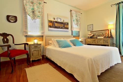 アテネにあるVouliagmeni Villaのベッドルーム(白いベッド1台、赤い椅子付)