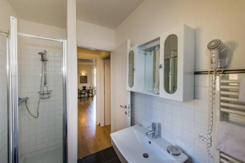 a white bathroom with a sink and a shower at Il Borgo Monolocali in Bellagio