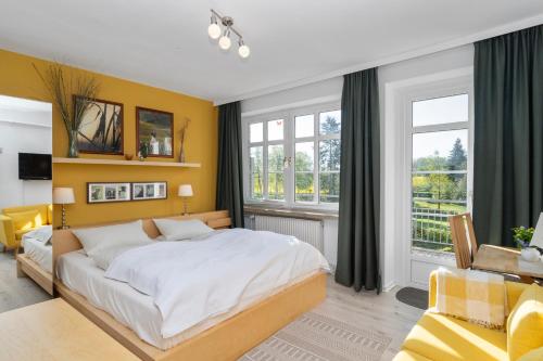 a bedroom with a large bed and a yellow wall at Ferienhof Radlandsichten in Malente