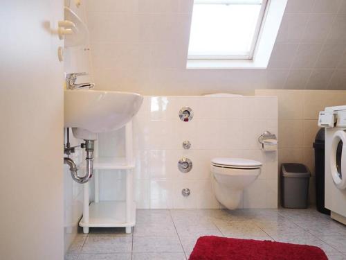 a bathroom with a sink and a toilet and a window at Stems-W4 in Prerow