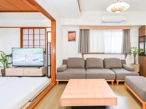 a living room with a couch and a tv at Home Stroy in Tokyo - 1970 Hotel- 江東区門前仲町 2min walk- 東京屋語 in Tokyo