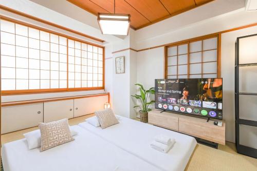 a room with two beds and a flat screen tv at Home Stroy in Tokyo - 1970 Hotel- 江東区門前仲町 2min walk- 東京屋語 in Tokyo