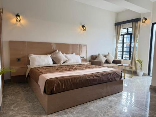 a bedroom with a large bed and a couch at The Notting Hills Inn in Shillong