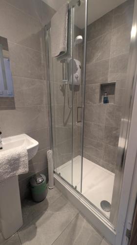 a bathroom with a shower and a sink at Buile Hill Holiday Flats in Llandudno